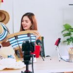 Young asian girl selling fashion hats and bags on social media by streaming live from her home.