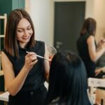 The makeup artist works in her salon, applies professional makeup.