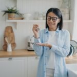 Smiling woman homeowner renter of new home showing keys of dwelling. Real estate sale or rental