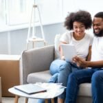 African Spouses Using Tablet Searching Apartment For Rent Online Indoor