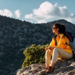 Portrait of a female traveler in the mountains. Adventure, travel and hiking concept