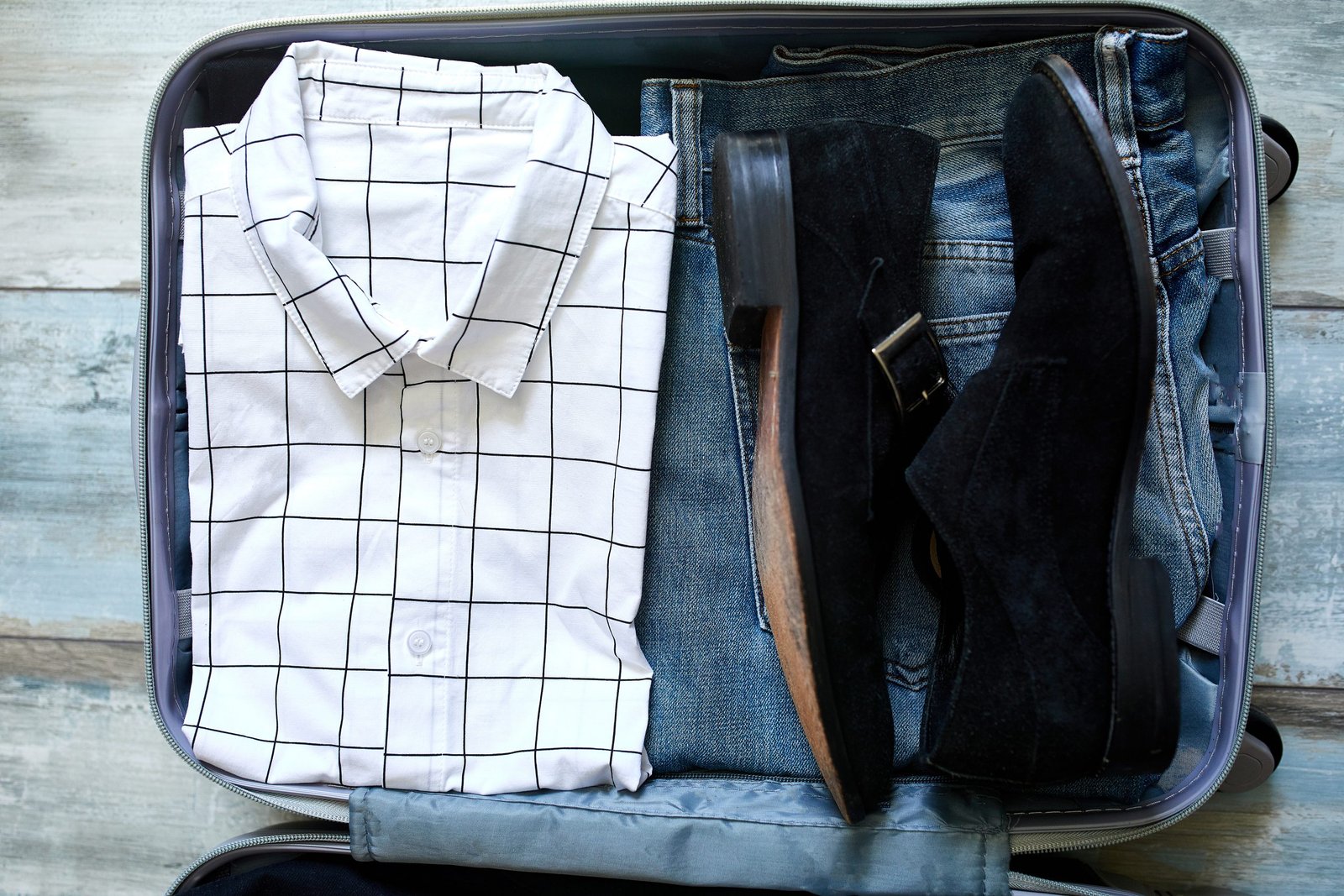 Packing suitcase at home with business man items