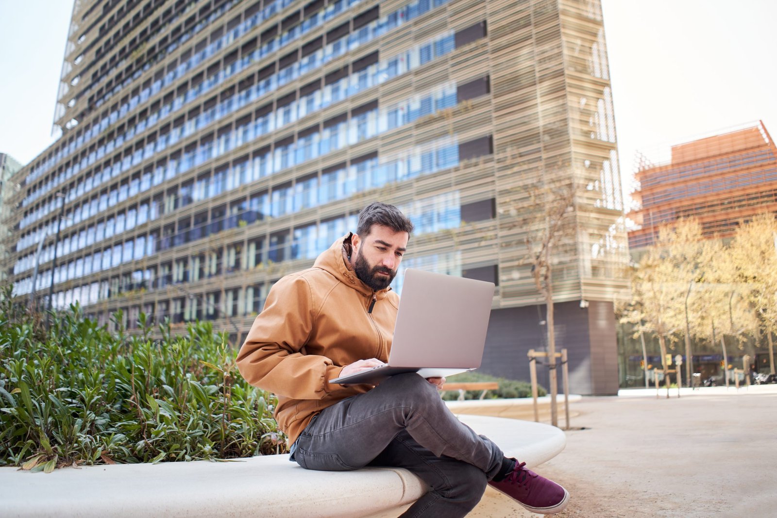 Business man typing on laptop computer outdoors