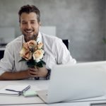 Happy businessman talking while having online date over laptop in the office.