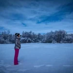 Best Time for Iceland to see auroras is during winter season and Karen Leblanc, aka the Design tourist is standing in the snow lookinng for northern lights to show up.