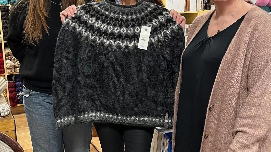 Karen holding a authentic Iceland handmade sweater from Icelandic wool.
