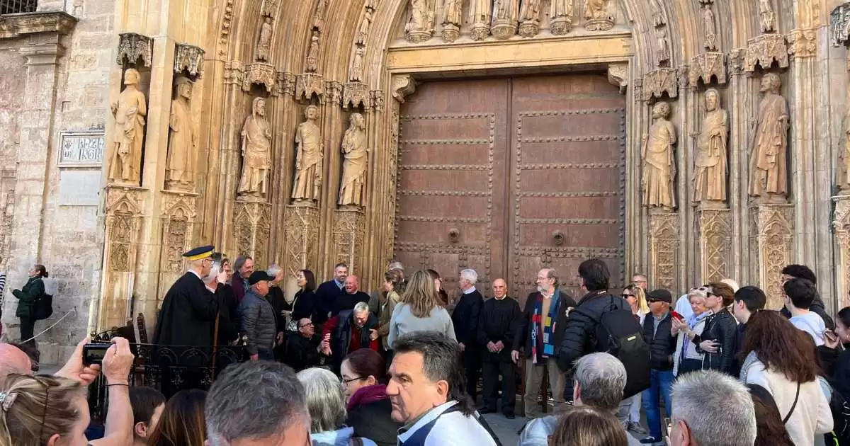 a group of people standing in front of a large wooden door