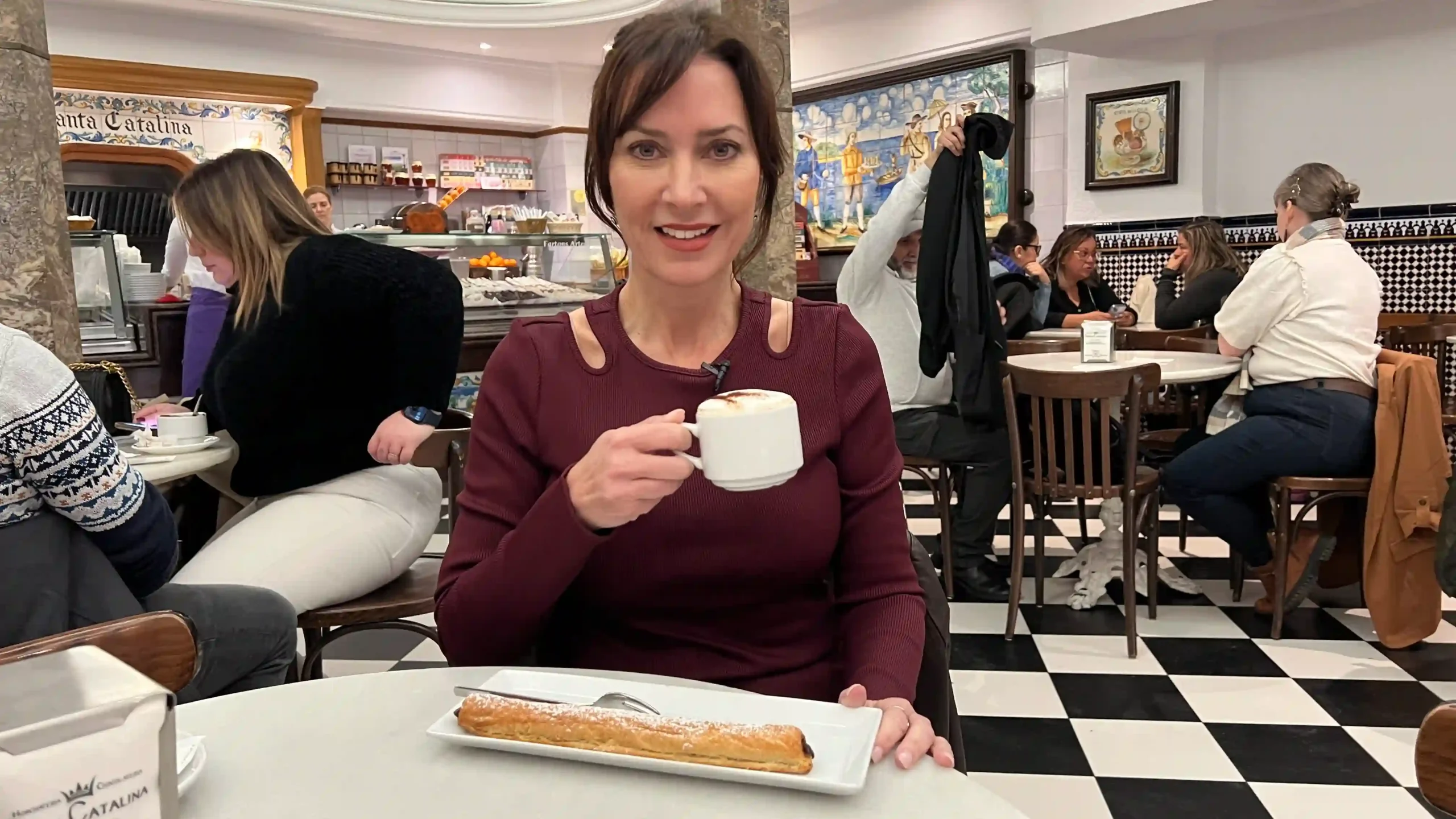 Karen sitting at a table holding a cup of coffee