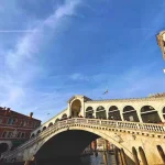 Rialto bridge over water with people walking on it.