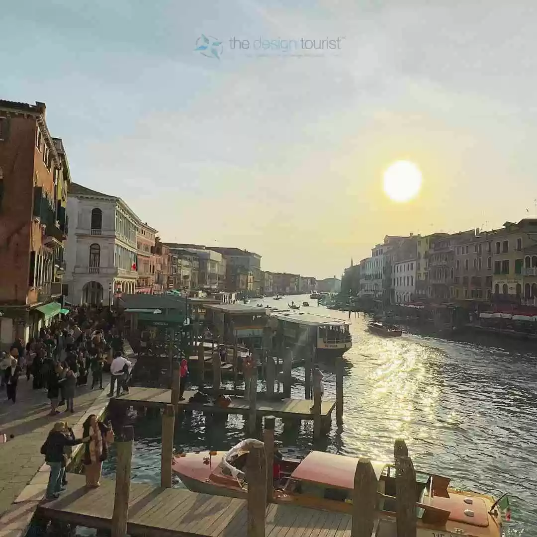 7 Must-Do Activities in Venice, Italy for an Unforgettable Trip Sunset over a busy venice canal with boats and pedestrians.