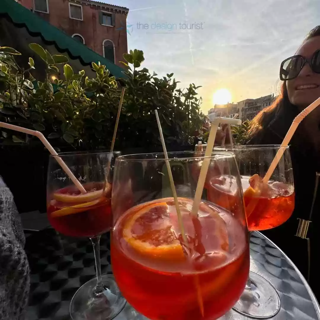 7 Must-Do Activities in Venice, Italy for an Unforgettable Trip three glasses with aperol spritz drinks on a table.