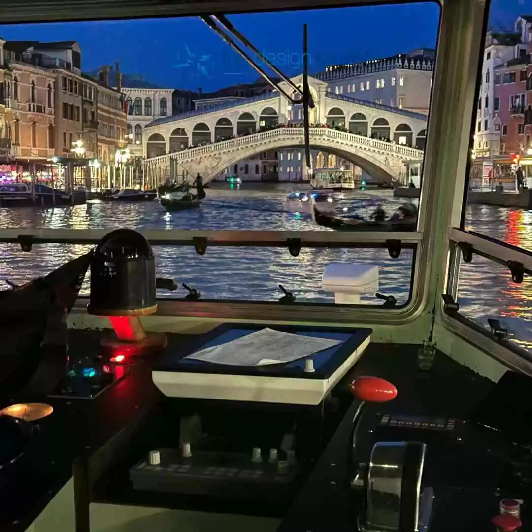 7 Must-Do Activities in Venice, Italy for an Unforgettable Trip Navigating canal at night via water taxi Illuminated bridge seen from Venetian water taxi boat.