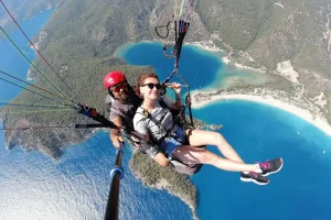 a man and woman paragliding over water