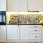 Beautiful home kitchen with white cabinets and backlight
