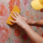 Builder smooths the wallpaper with a spatula.