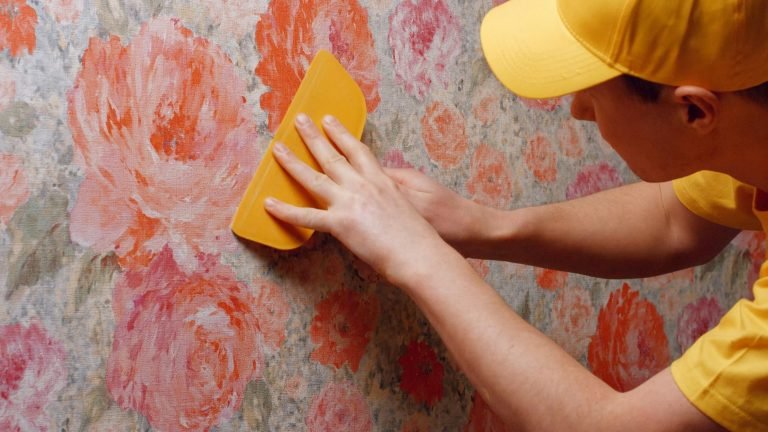 Builder smooths the wallpaper with a spatula.