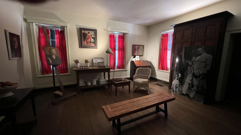 A living room with a wooden table and red curtains.