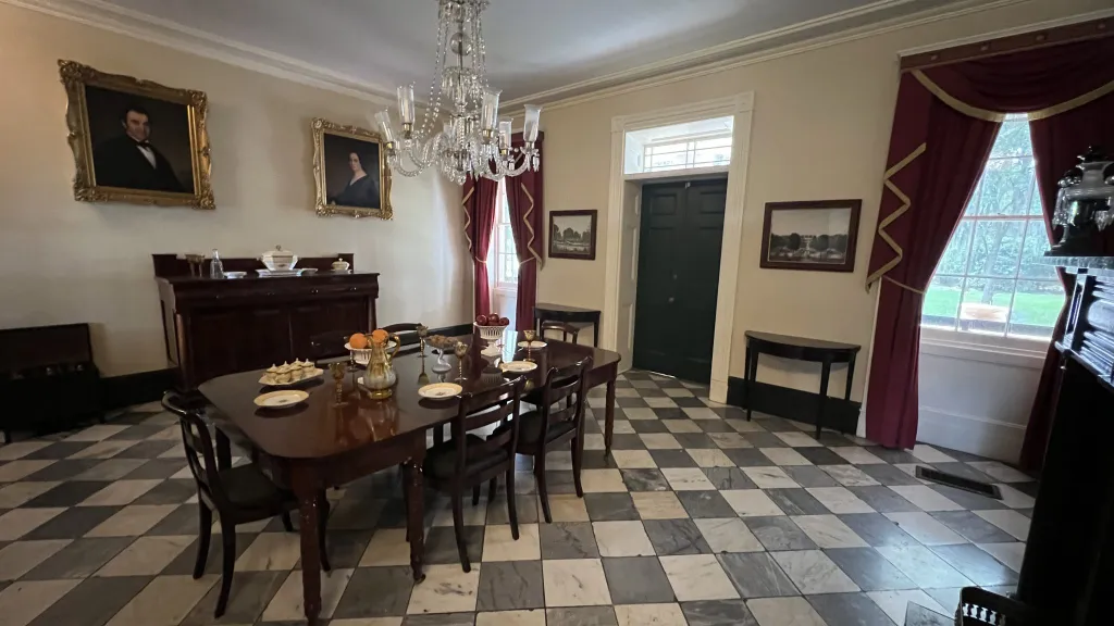 A dining room with a checkered floor and a chandelier