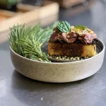 Horse Tataki dish in a plate with green garnish.