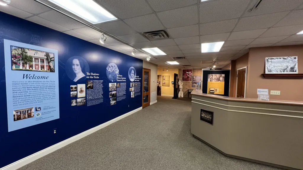 A hallway with a blue wall and pictures on the wall