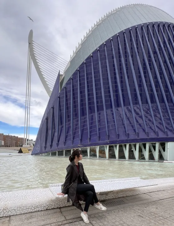 Karen sitting with the Agora Building background.
