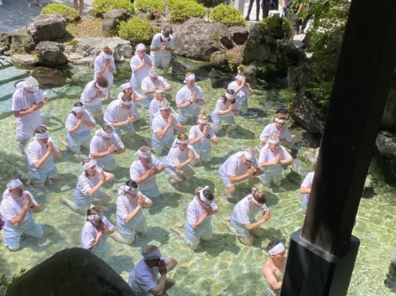 a group of people standing in a pool of water at Mt. Hakusan Japan.