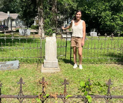 Karen standing in front of a grave in American Cemetery