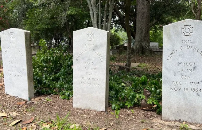 a couple of cement headstones sitting in the grass of The Russell Family.
