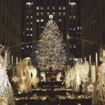 a large christmas tree surrounded by angel statues in nyc