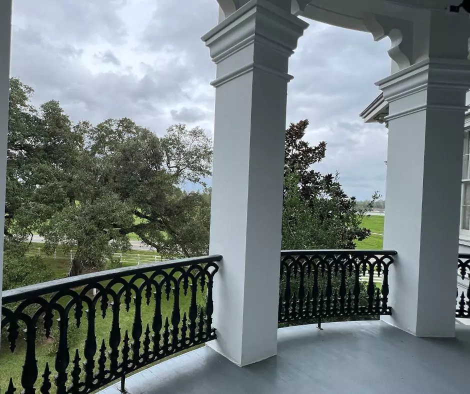 a balcony with pillars and a fence of Nottoway Mansion