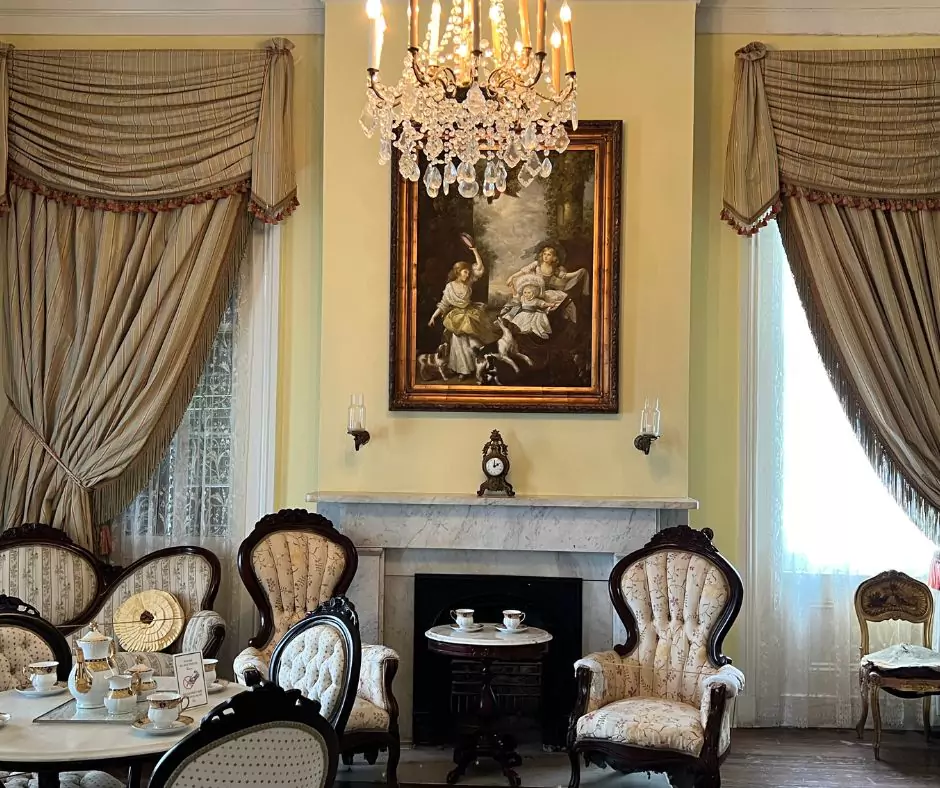 a room with a fireplace and chandelier of Nottoway Mansion