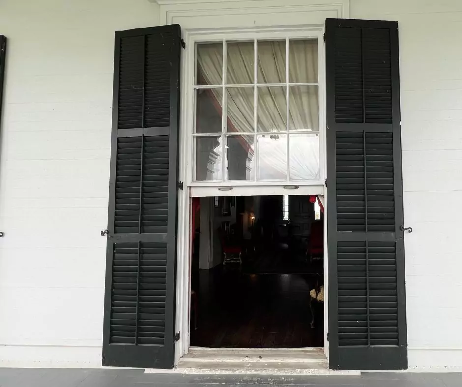 a white building with black shutters of Nottoway Mansion