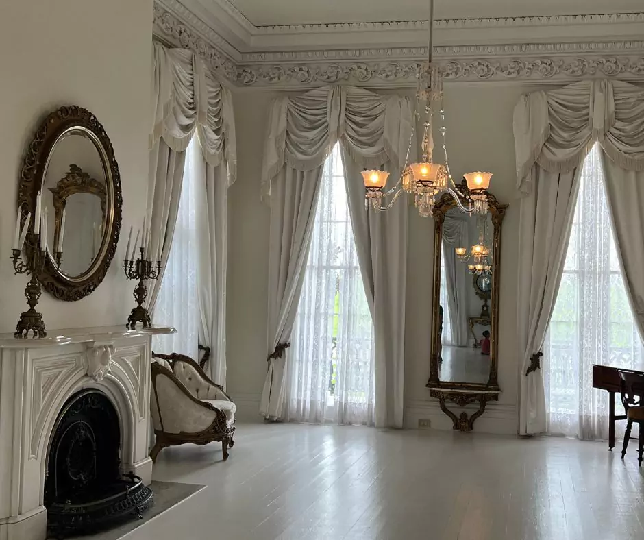 a room with a fireplace and chandelier of Nottoway Mansion