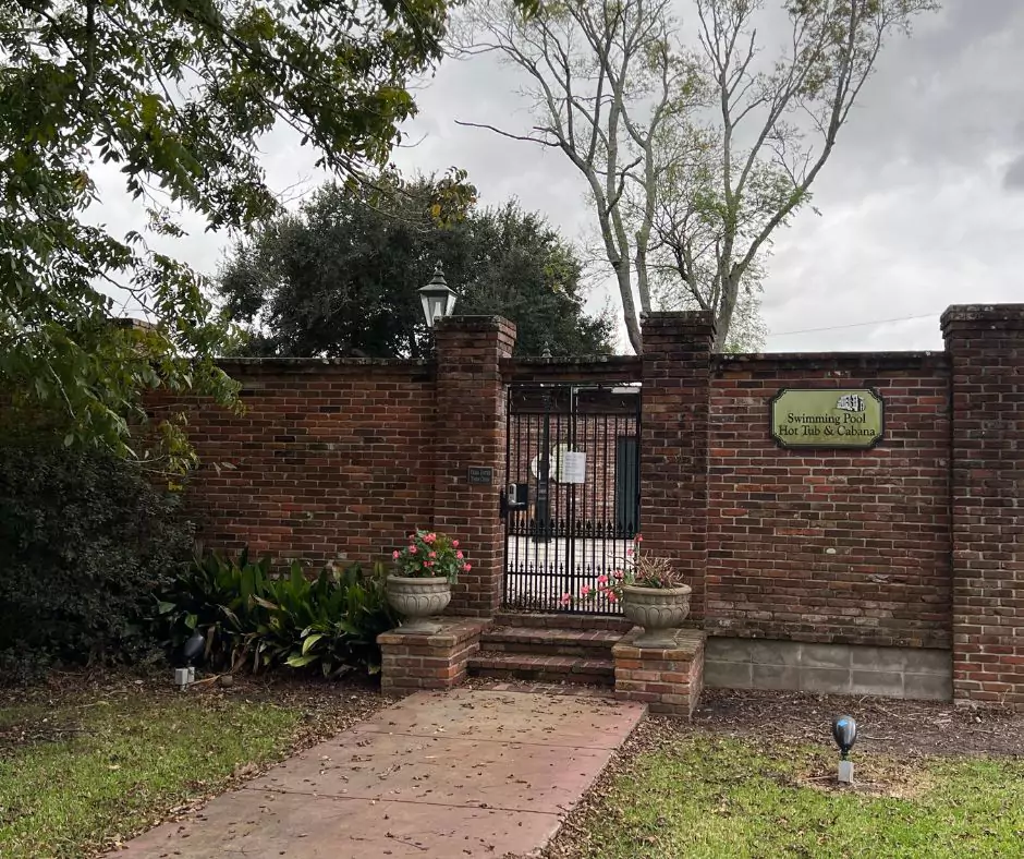 a brick wall with a gate and a sign of Nottoway Resort - Largest Antebellum Mansion