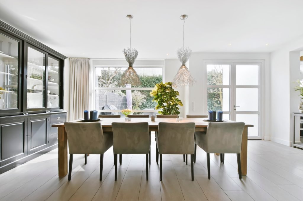 A minimalist dining room with two chandeliers