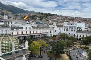 a large white building with a yellow and red flag on top of it in Quito. Is Quito safe for tourist?