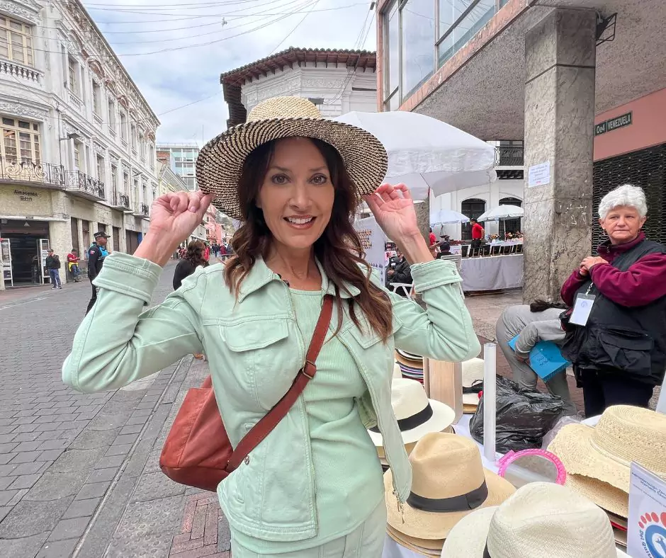 KAren wearing a hat and a green shirt strolling in the streets of Old town Quito