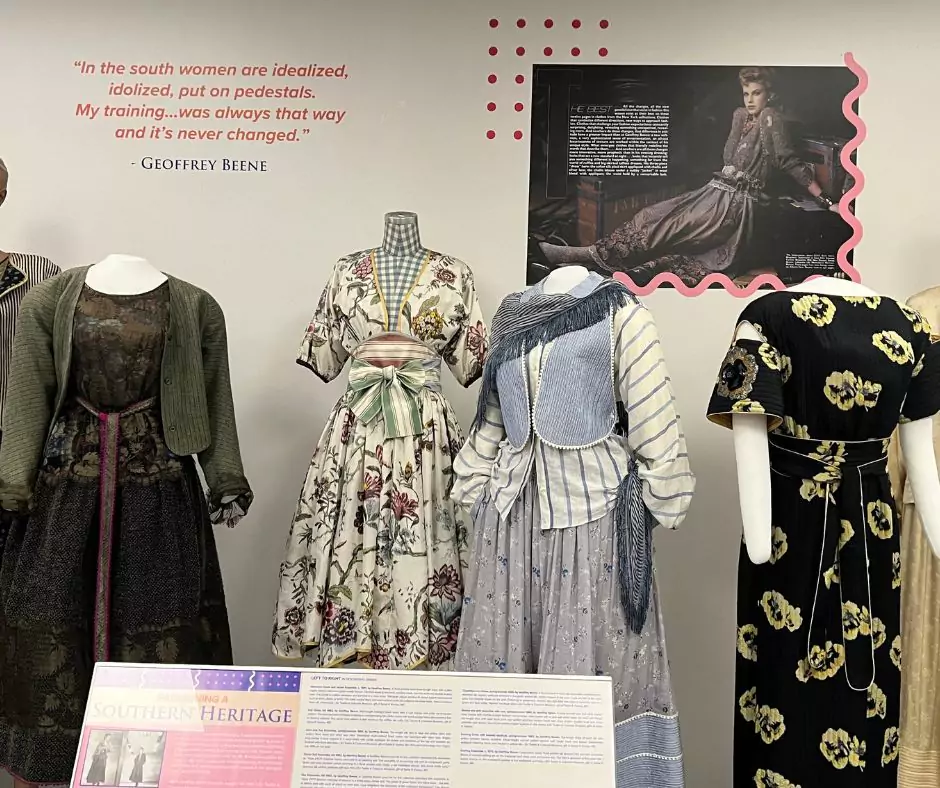 A Geoffrey Beene exhibit showcasing vintage dresses with floral patterns, delicate lace, and structured silhouettes. A quote by Beene about Southern fashion is displayed above, reinforcing his design inspiration.