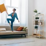 Carefree Woman Jumping and Dancing with Joy in Beautiful Home Interior