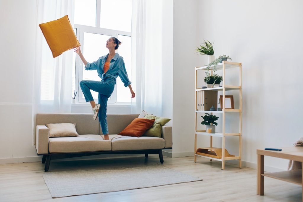 Carefree Woman Jumping and Dancing with Joy in Beautiful Home Interior