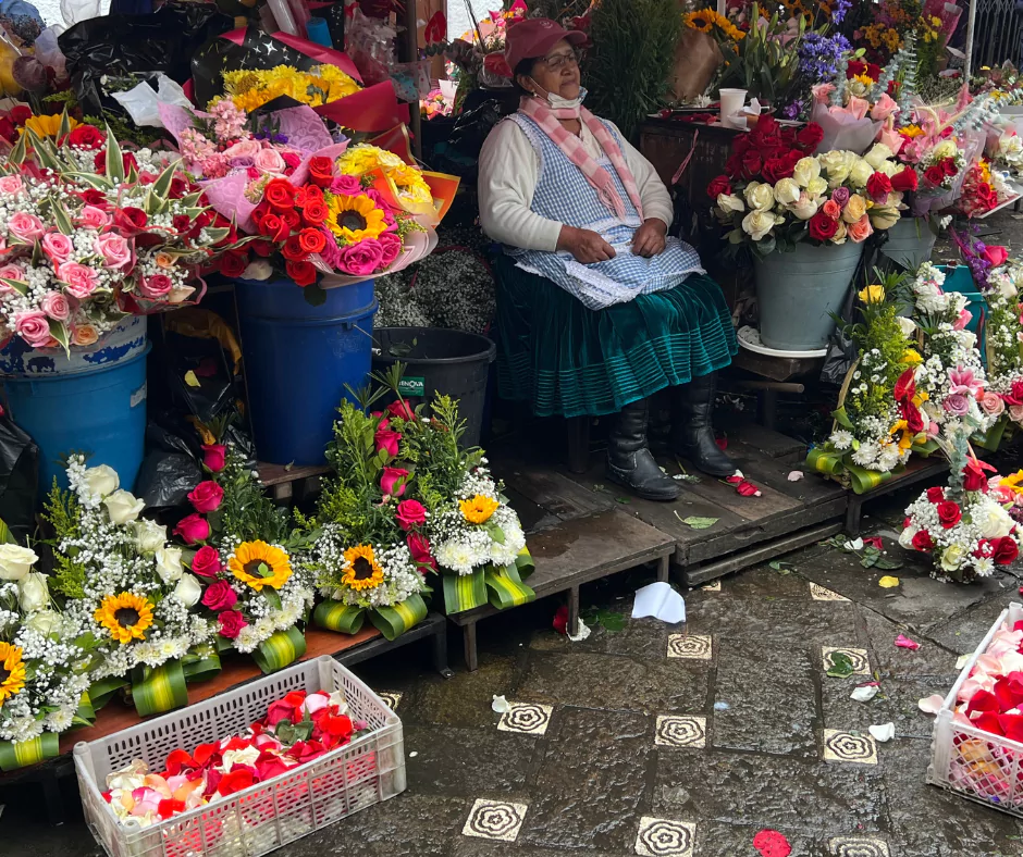 a woman selling ecuador roses and other flowers
