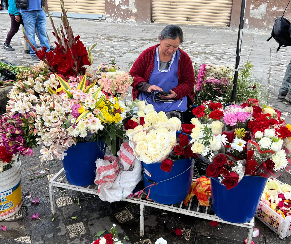 a woman selling ecuador roses and other flowers