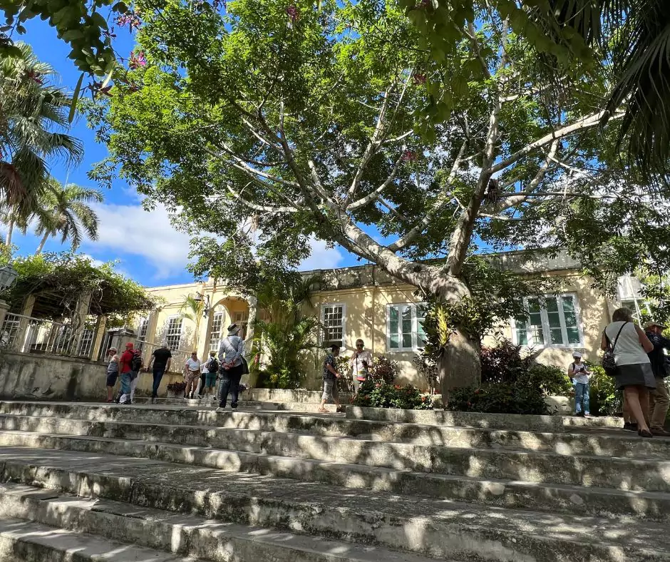 a group of people walking down the steps of a house of ernest hemingway in cuba.