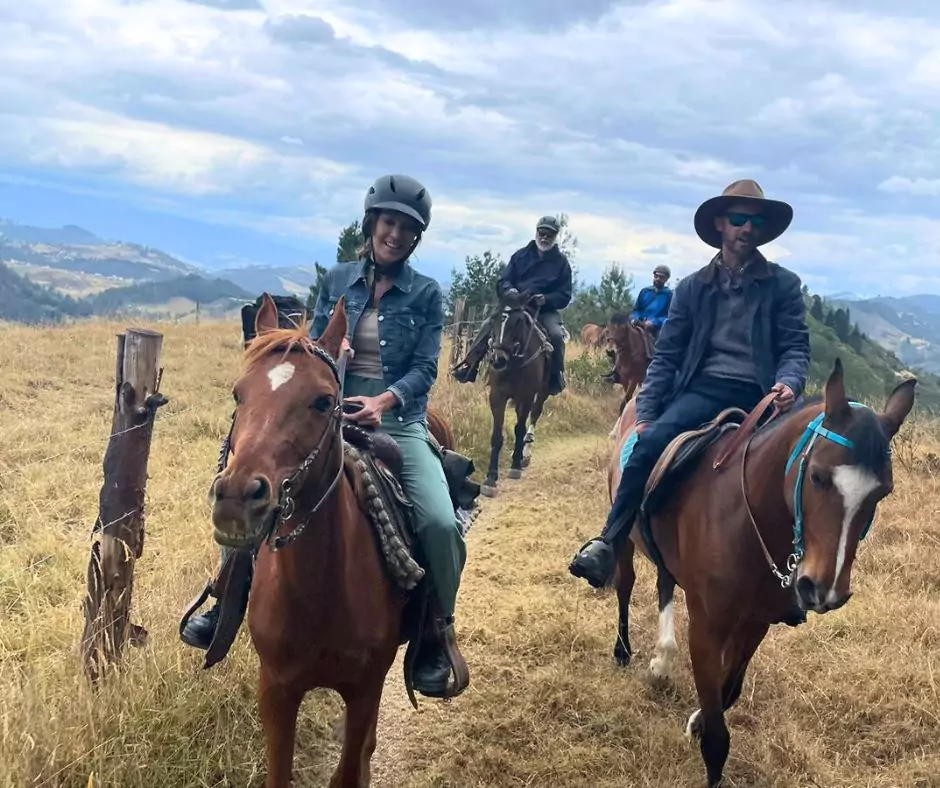 a group of people riding horses on a trail