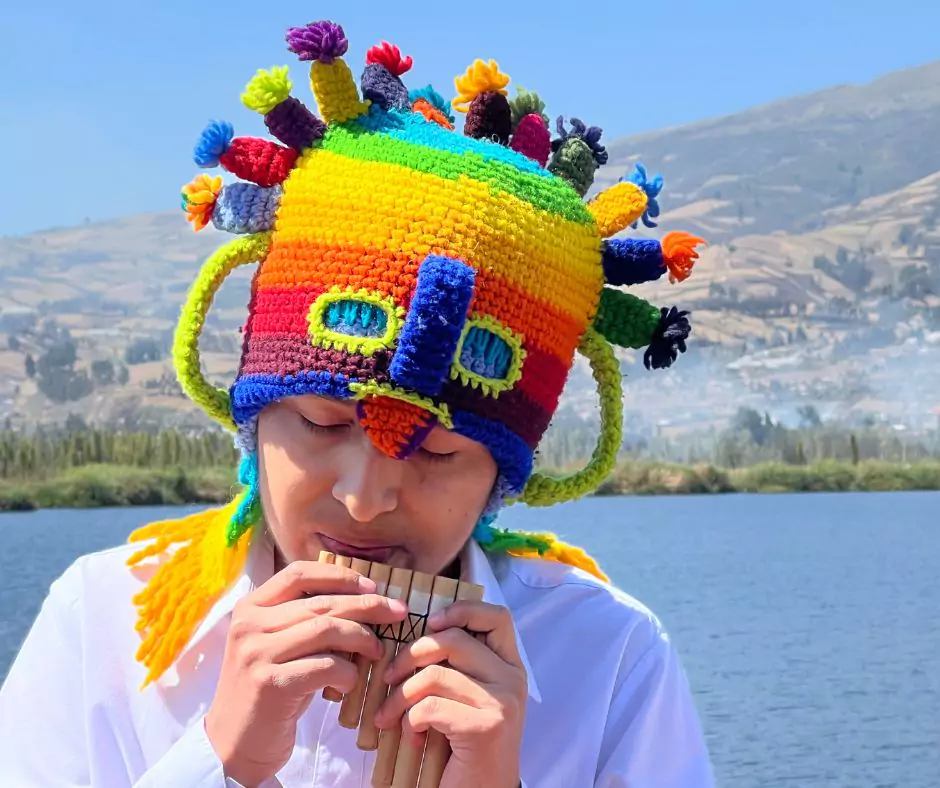 Kevin wearing Aya Huma mask playing instrument at San Pablo Lake in Ecuador