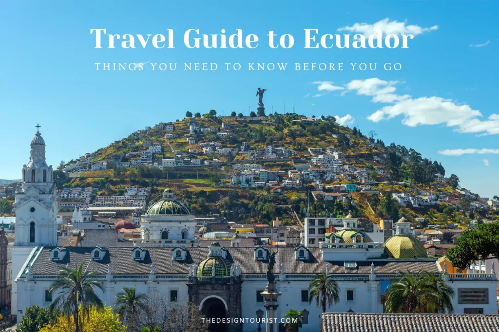 Scenic view of Quito, Ecuador with colonial architecture in the foreground and the Virgin of El Panecillo statue atop a hill surrounded by colorful hillside homes under a bright blue sky. Text overlay reads "Travel Guide to Ecuador – Things You Need to Know Before You Go."