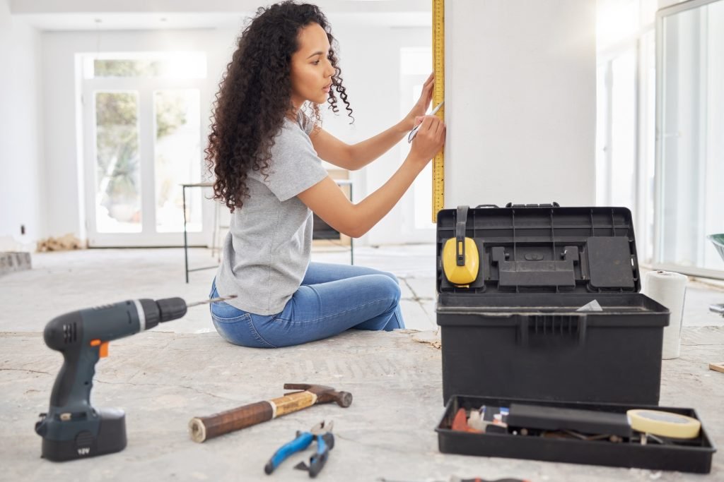 Its time for a home update. Shot of a woman using a spirit level while renovating a house.