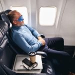 Man in the sleep mask relaxing on the plane