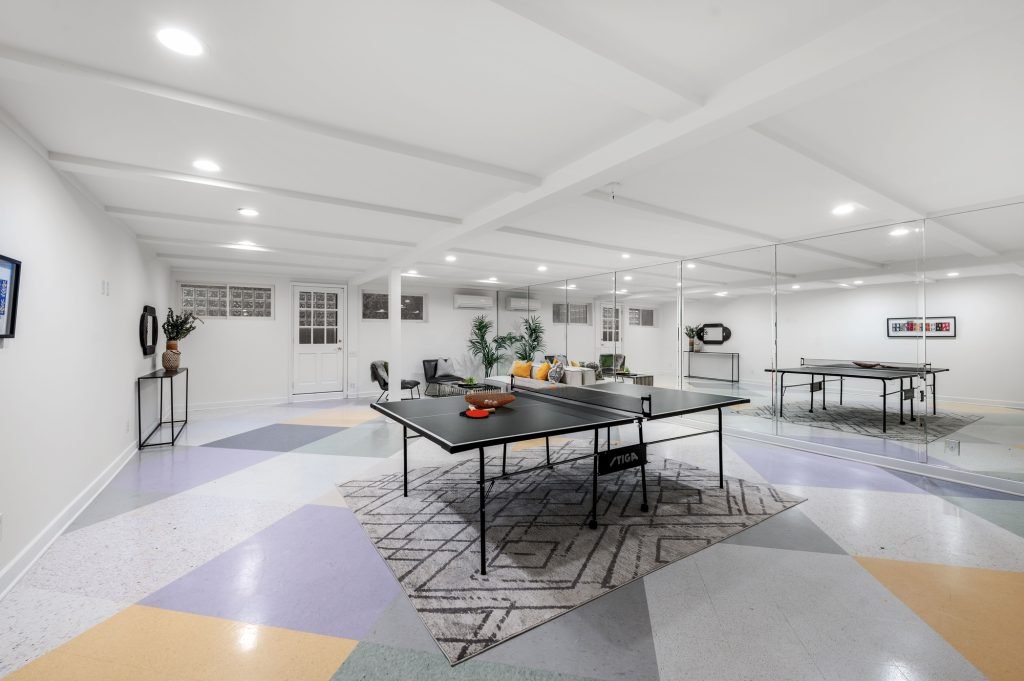 Modern basement game room with ping pong table.