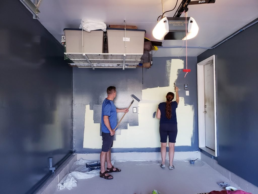 Two painters in the garage painting walls, small business, renovation, work, husband and wife
